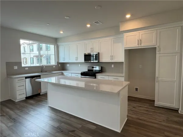 a kitchen with a sink a stove a refrigerator and cabinets
