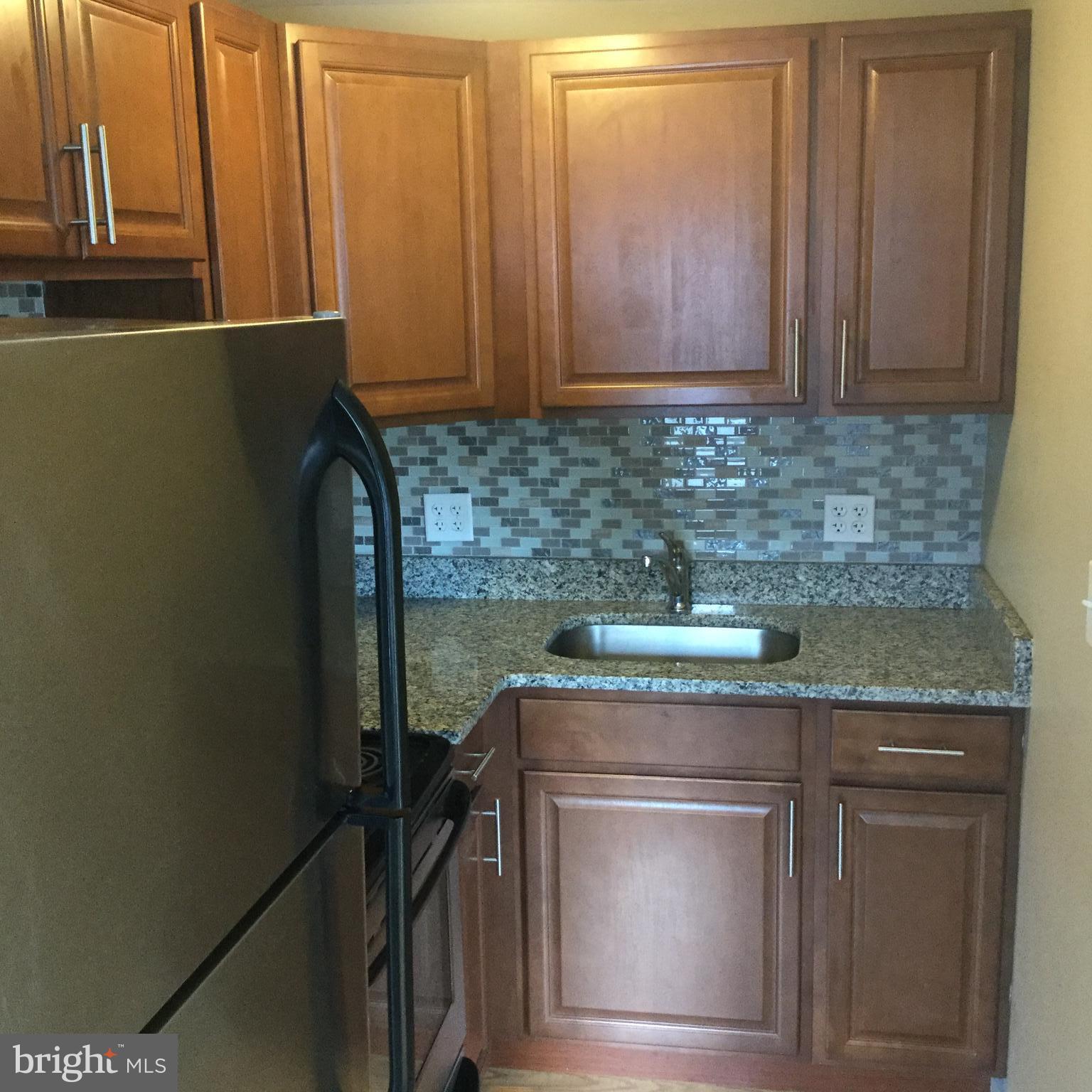 1725 Light Street Baltimore, MD 21230 - Photo 2 of 10 a kitchen with granite countertop cabinets washer and dryer