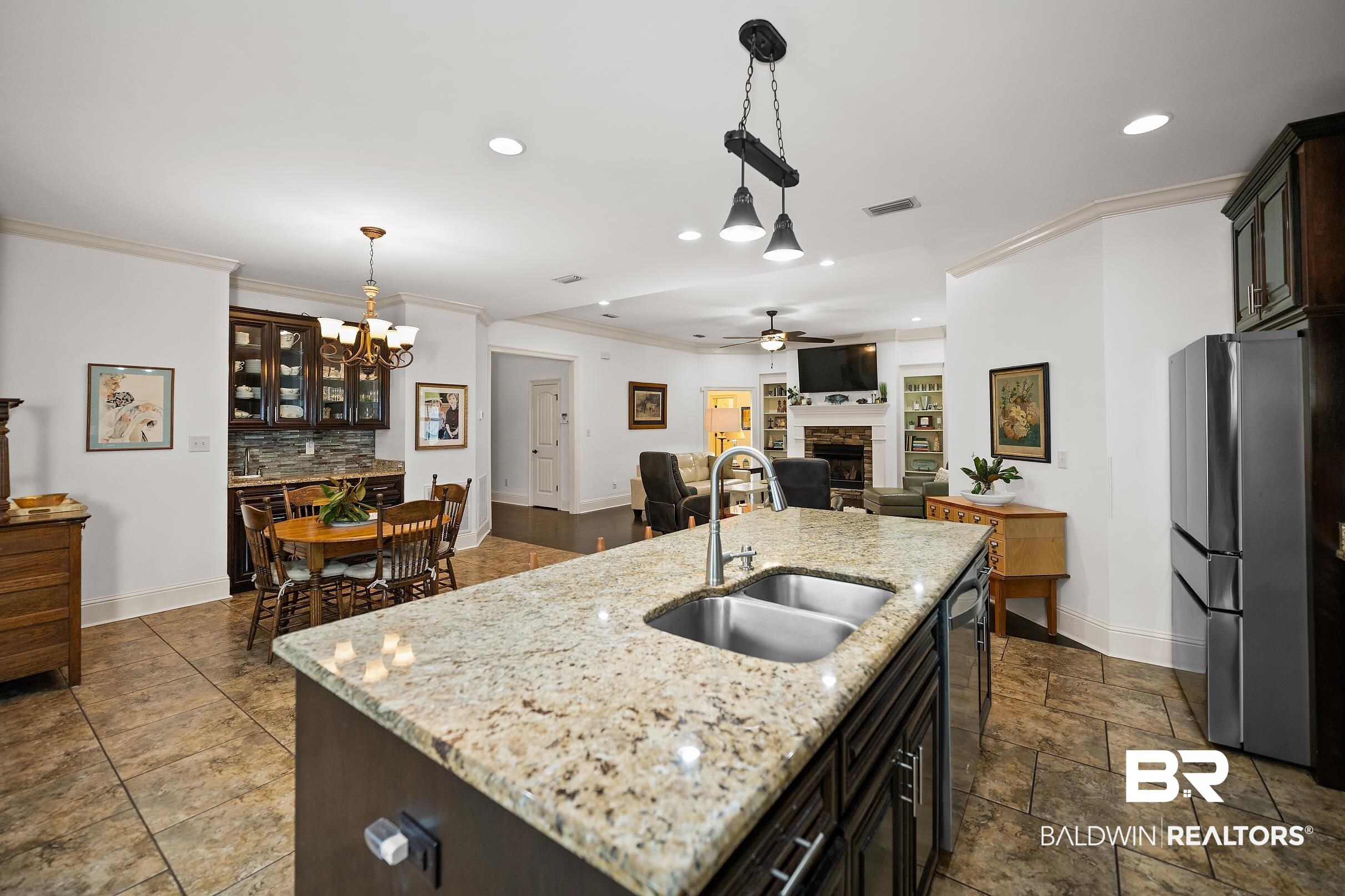 313 Pecan Ridge Boulevard Fairhope, AL 36532 - Photo 6 of 51 Kitchen island featuring a double basin stainless steel sink, a chrome faucet, and a light-toned granite countertop