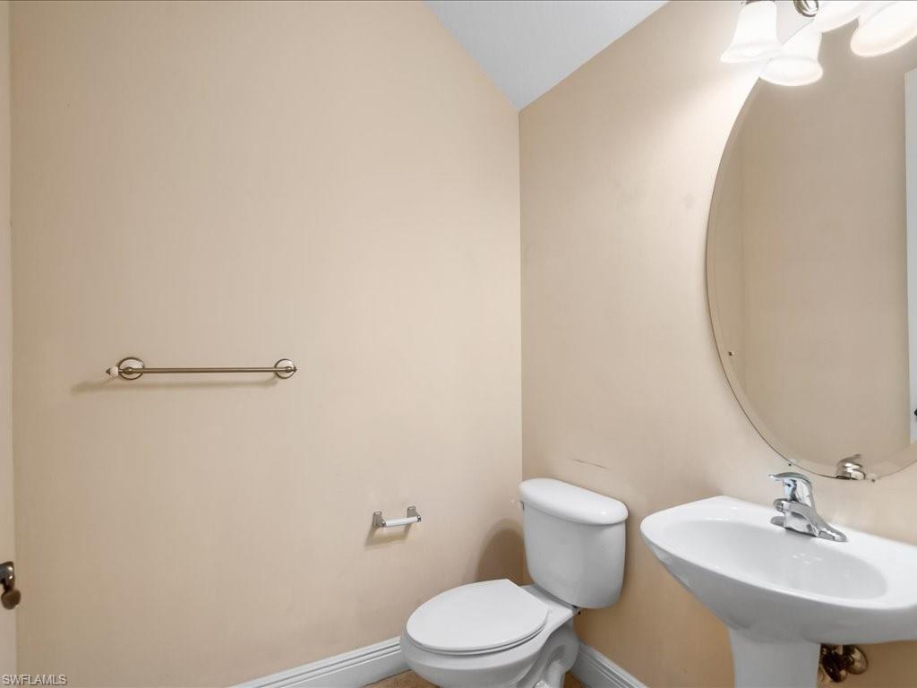 2055 Par Drive Naples, FL 34120 - Photo 24 of 32 a bathroom with a sink a mirror and a toilet