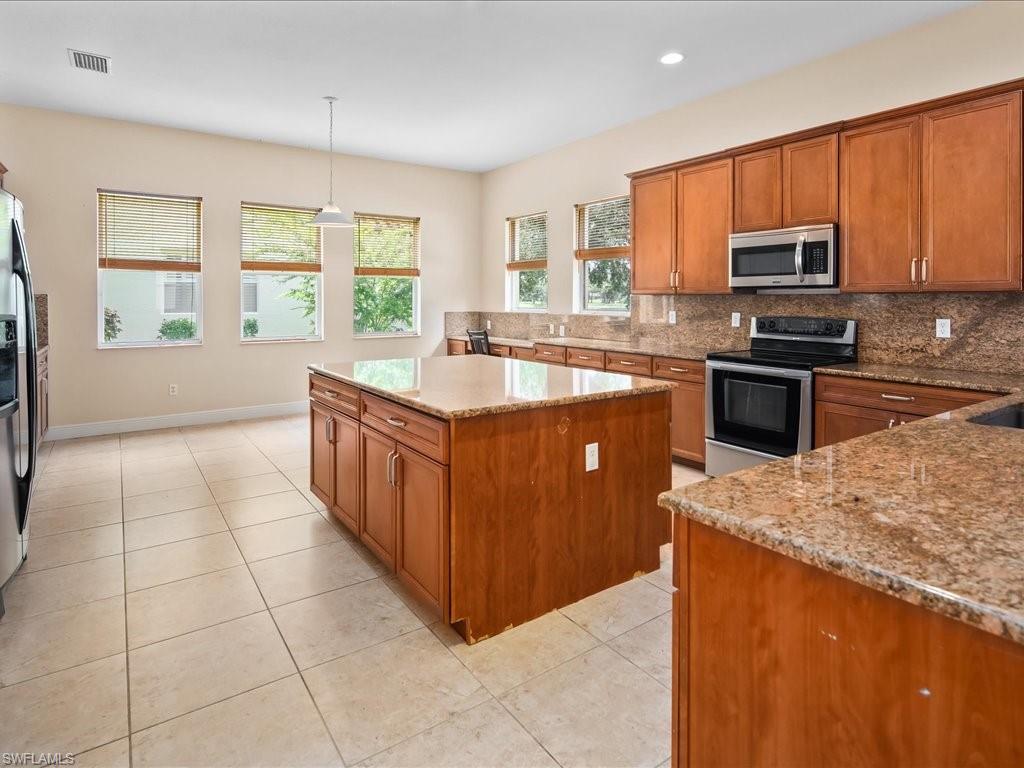 2055 Par Drive Naples, FL 34120 - Photo 5 of 32 a kitchen with stainless steel appliances granite countertop a stove a sink a microwave and a refrigerator