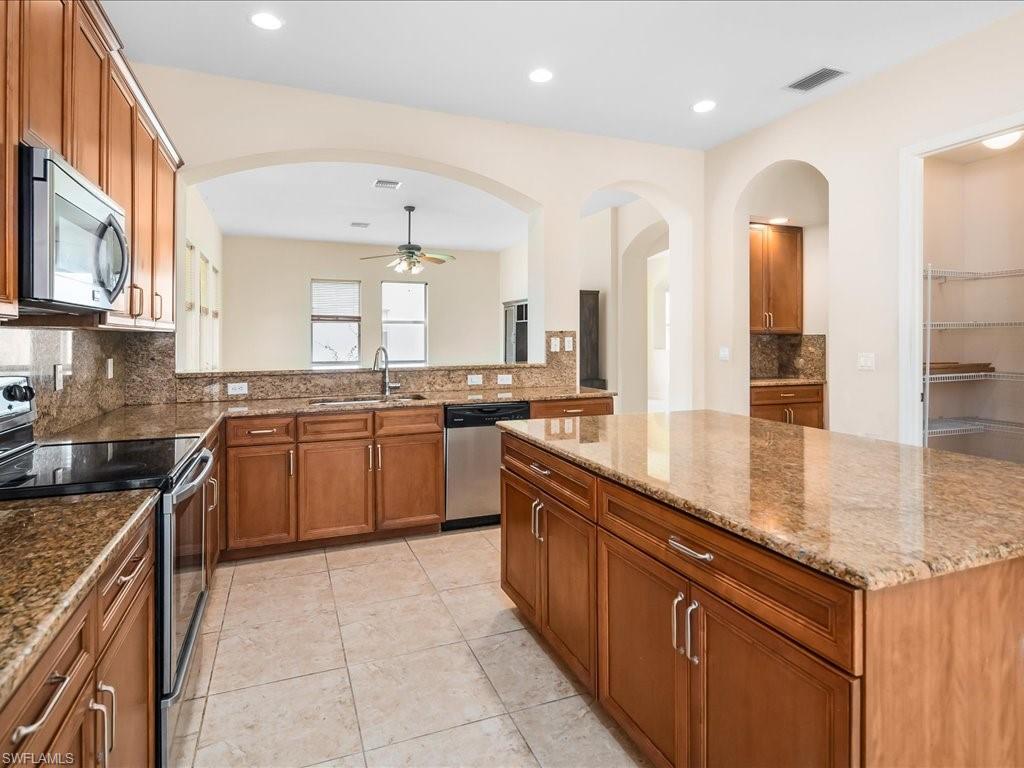 2055 Par Drive Naples, FL 34120 - Photo 7 of 32 a large kitchen with stainless steel appliances granite countertop a stove sink and cabinets