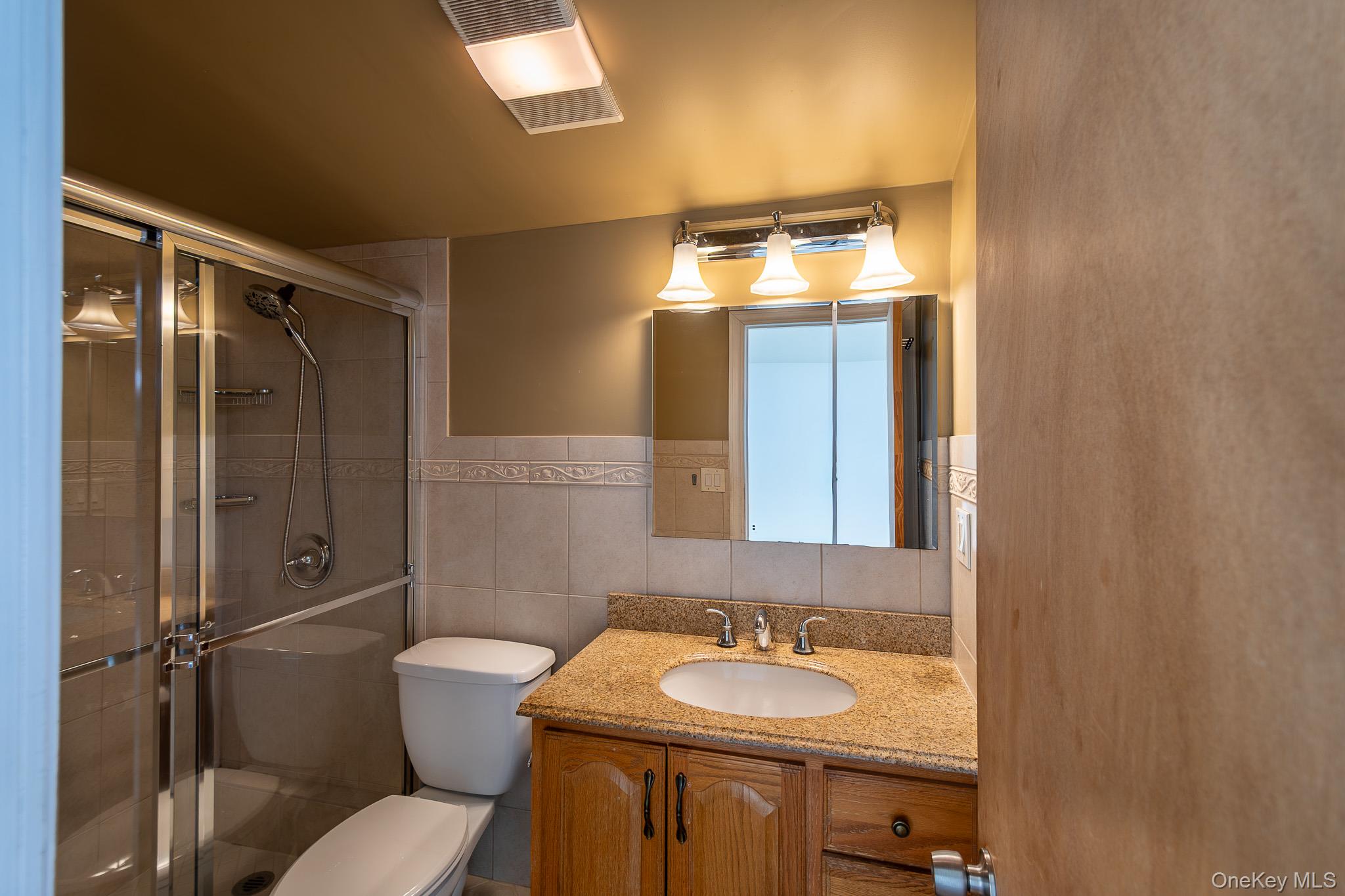83 Edgepark Road White Plains, NY 10603 - Photo 19 of 25 a bathroom with a sink and mirror with toilet