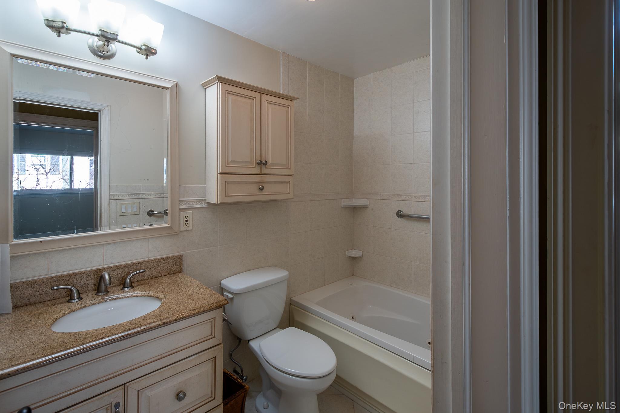 83 Edgepark Road White Plains, NY 10603 - Photo 24 of 25 a bathroom with a granite countertop toilet a sink and a bathtub