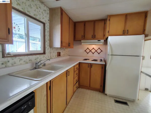 a kitchen with a refrigerator sink and cabinets