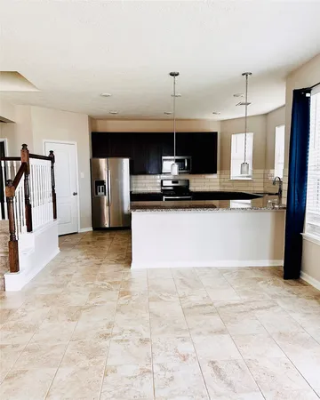 a kitchen with stainless steel appliances granite countertop a refrigerator and a stove top oven