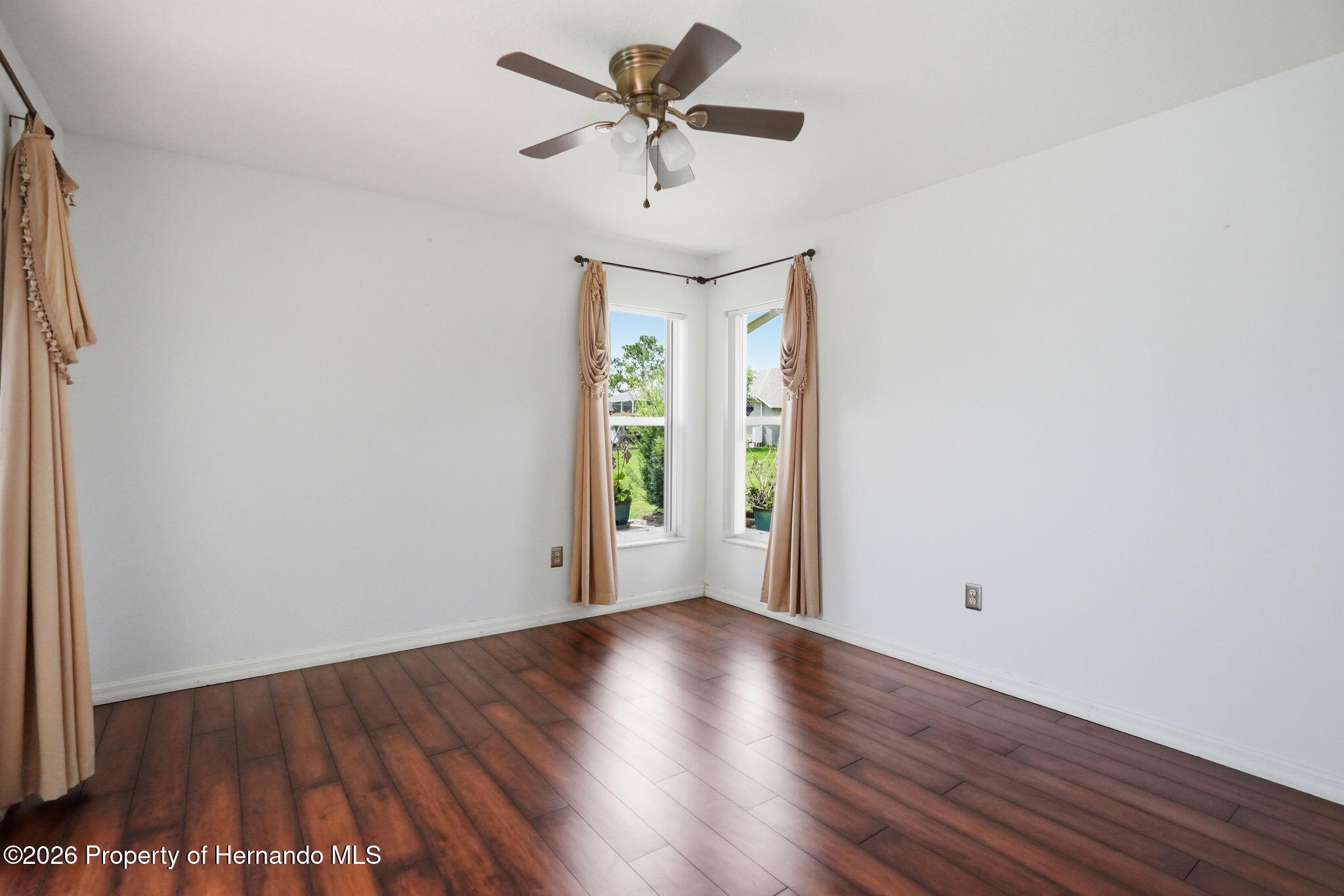 18131 Rivard Boulevard Brooksville, FL 34604 - Photo 38 of 66 a view of a room with wooden floor a ceiling fan and a window