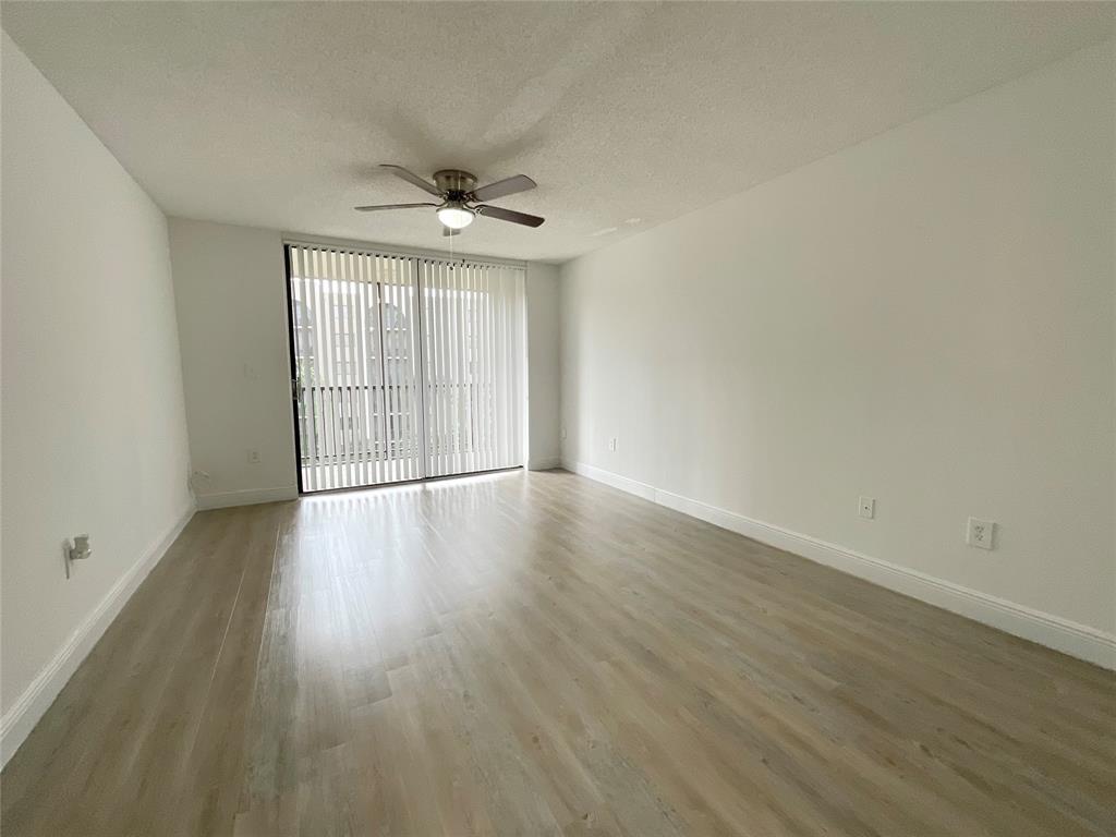 9517 Fontainebleau Boulevard, Unit 581315 Miami, FL 33172 - Photo 2 of 17 wooden floor in an empty room with a window