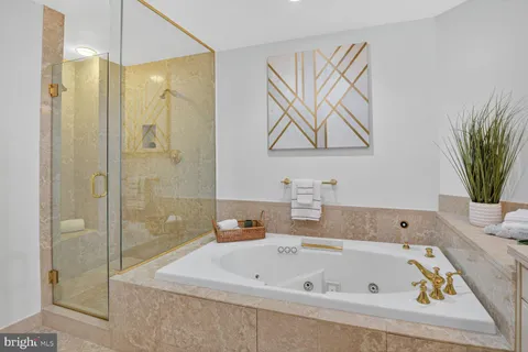 a bathroom with a tub a sink and glass door shower