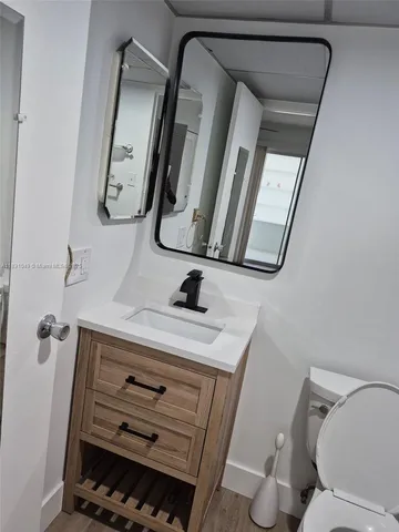 a bathroom with a toilet a sink and mirror