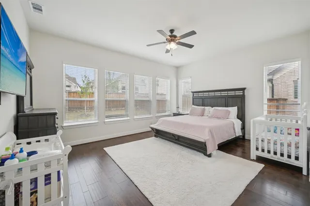 a bedroom with a bed and flat tv screen on the dresser