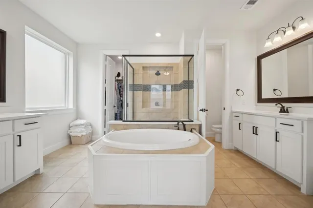 a spacious bathroom with a tub sink and mirror