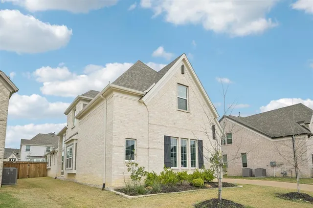 a view of a white house next to a yard