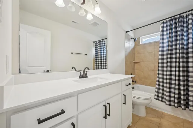 a bathroom with a sink a toilet a mirror and shower