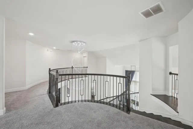 a view of a hallway with a chandelier fan