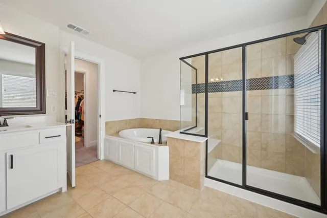 a spacious bathroom with a tub mirror and shower