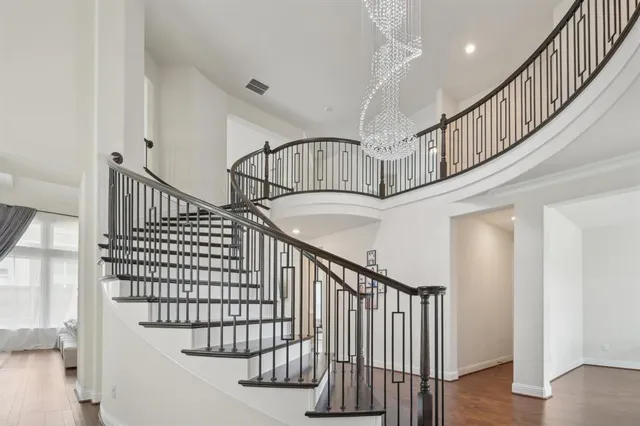 a view of staircase with wooden floor and white walls