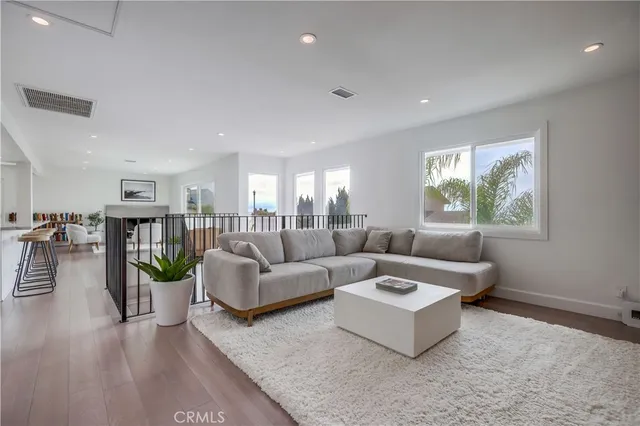 a living room with furniture and a view of kitchen