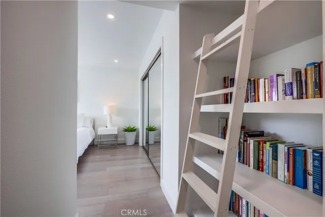 a bedroom with a bed a tv and wooden floor