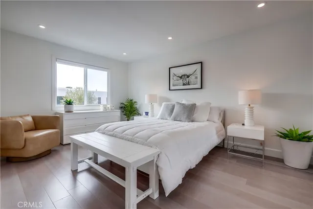 a bedroom with a bed and a potted plant