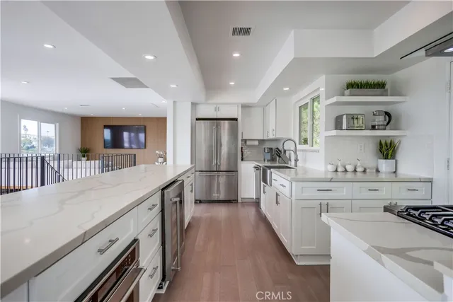 a large kitchen with stainless steel appliances lots of counter space and wooden floor