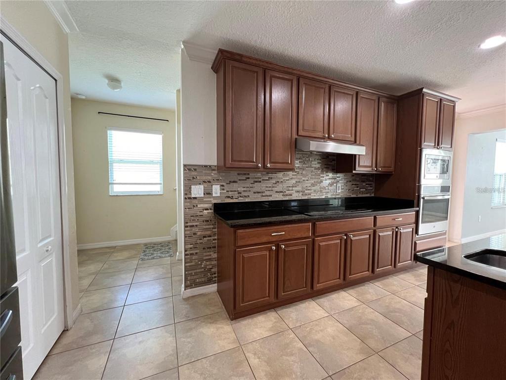 3003 Cobham Road Kissimmee, FL 34758 - Photo 12 of 43 a kitchen with stainless steel appliances granite countertop a stove a sink and a refrigerator