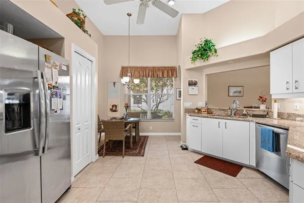 a kitchen with granite countertop white cabinets and stainless steel appliances