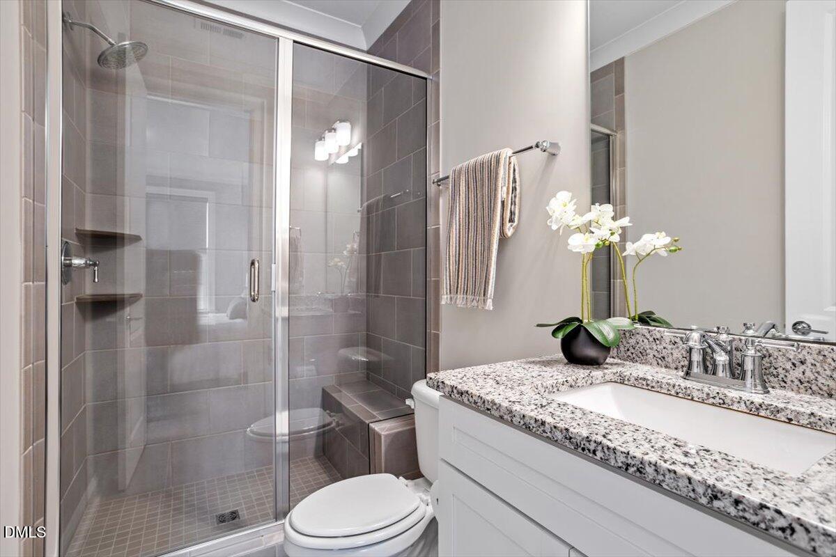 2844 Spring Shade Road Apex, NC 27523 - Photo 23 of 48 a bathroom with a granite countertop sink toilet and shower