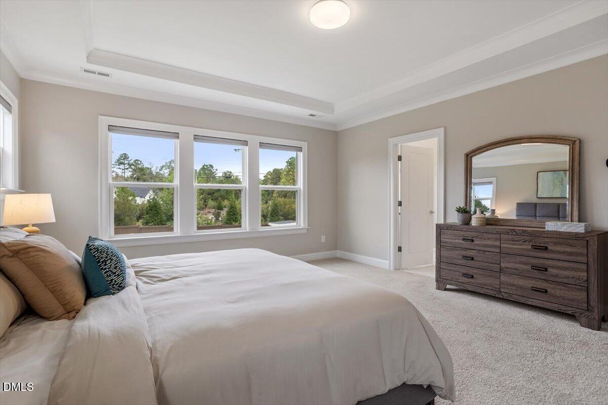 2844 Spring Shade Road Apex, NC 27523 - Photo 26 of 48 a bed room with a bed and a mirror on dresser