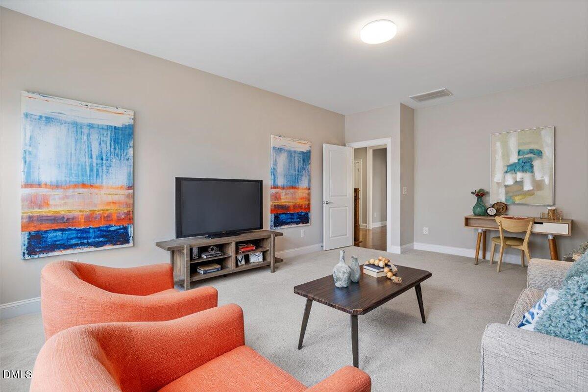 2844 Spring Shade Road Apex, NC 27523 - Photo 33 of 48 a living room with furniture and a flat screen tv
