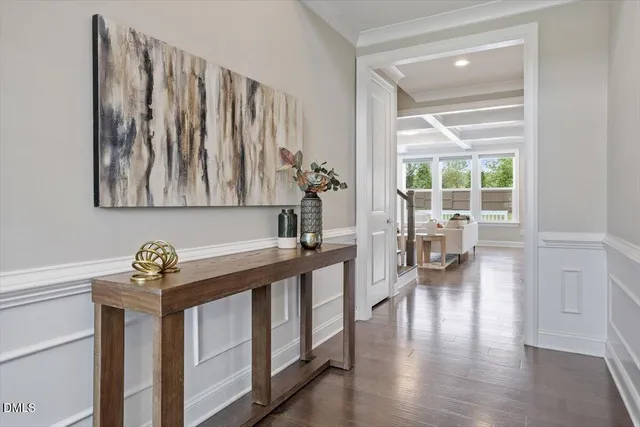 a hallway with a wooden floor and a potted plant on a table