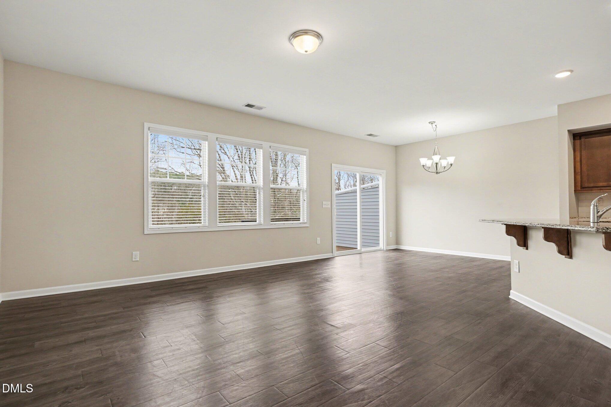 4245 Lofty Ridge Place Morrisville, NC 27560 - Photo 6 of 31 a view of an empty room with wooden floor and a window