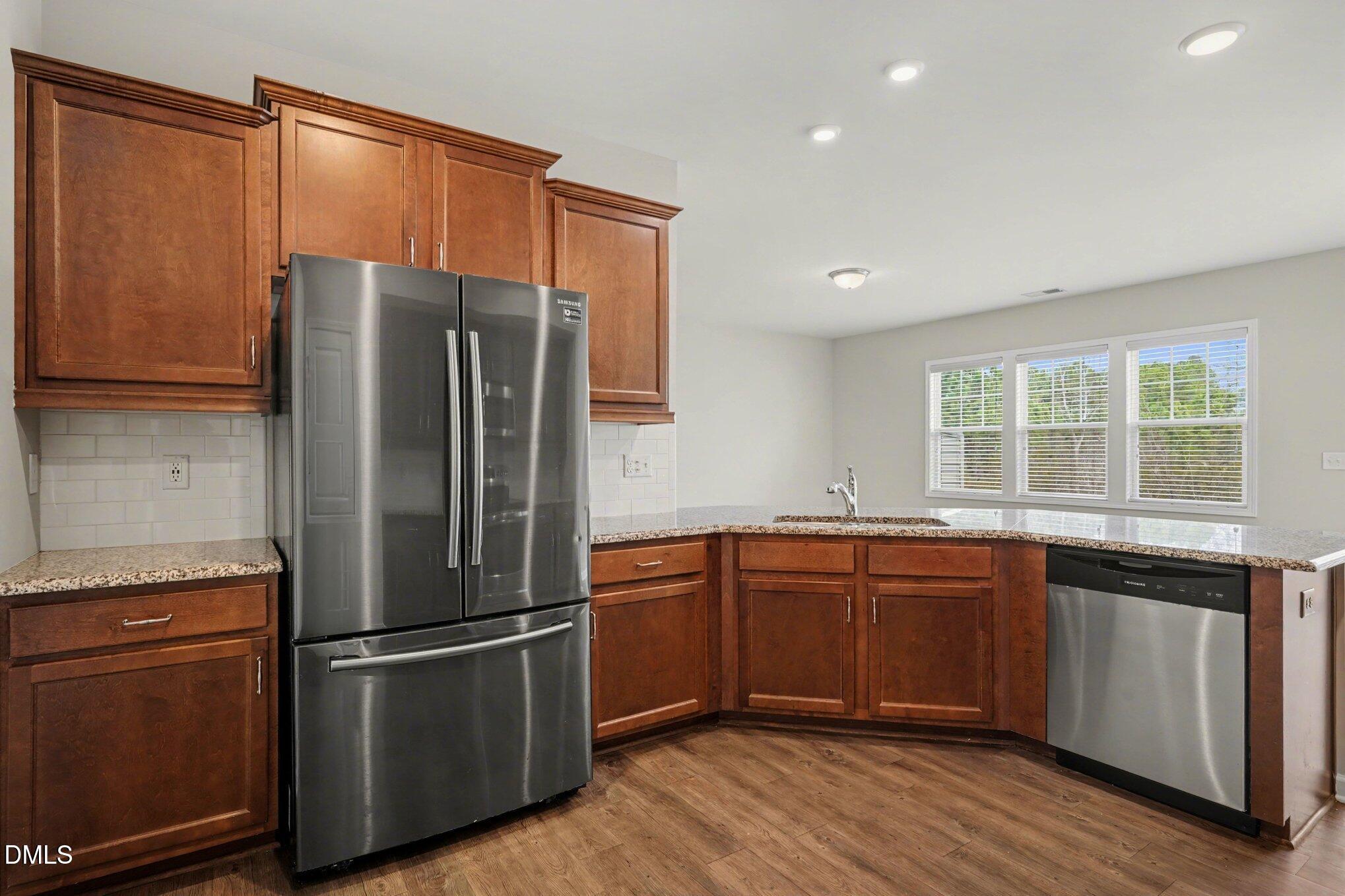 4245 Lofty Ridge Place Morrisville, NC 27560 - Photo 9 of 31 a kitchen with stainless steel appliances granite countertop a refrigerator and a sink