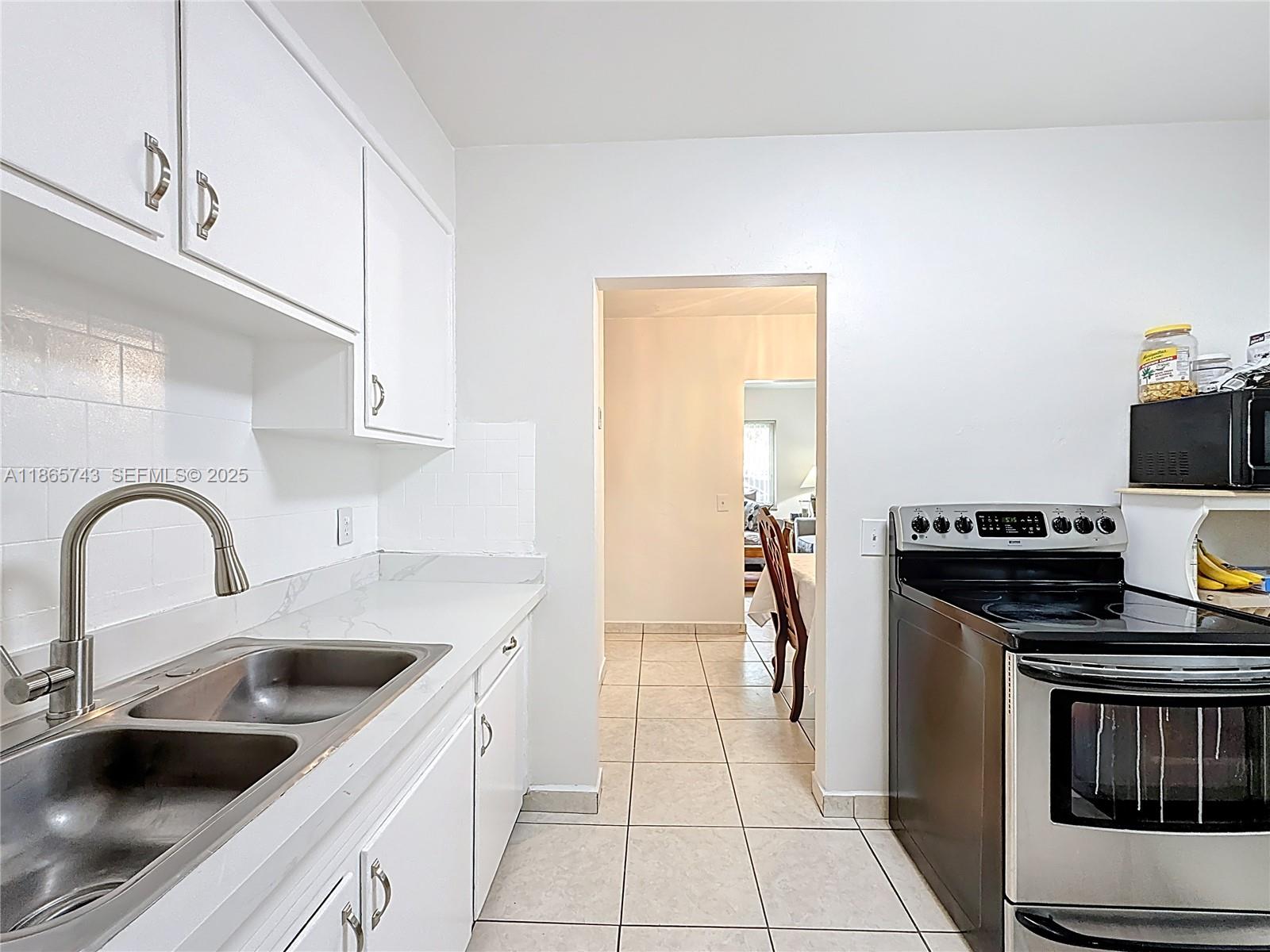 675 West 30th Street Hialeah, FL 33012 - Photo 6 of 17 a kitchen with stainless steel appliances a sink stove and cabinets
