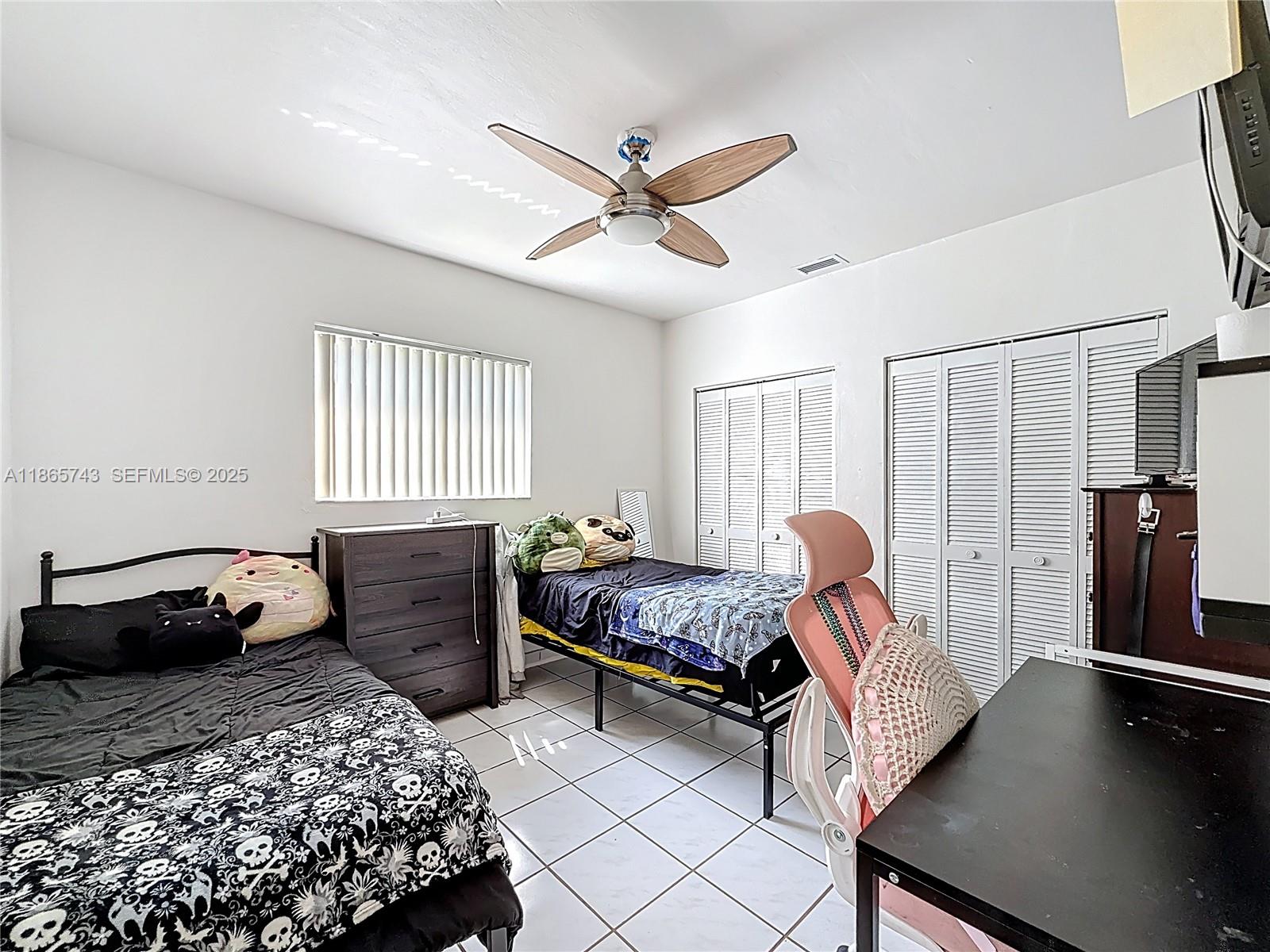 675 West 30th Street Hialeah, FL 33012 - Photo 9 of 17 a bedroom with a bed and a chandelier