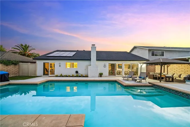 a front view of a house with a yard and potted plants