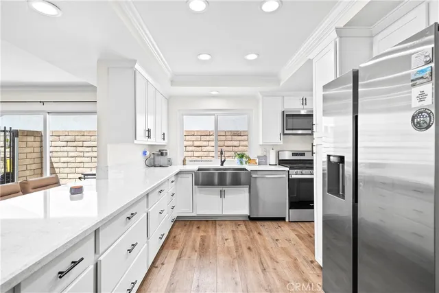 a kitchen with kitchen island a counter top space cabinets and stainless steel appliances