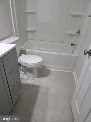 a white toilet sitting next to a bath tub