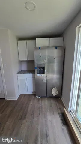 a kitchen with granite countertop a refrigerator and a sink