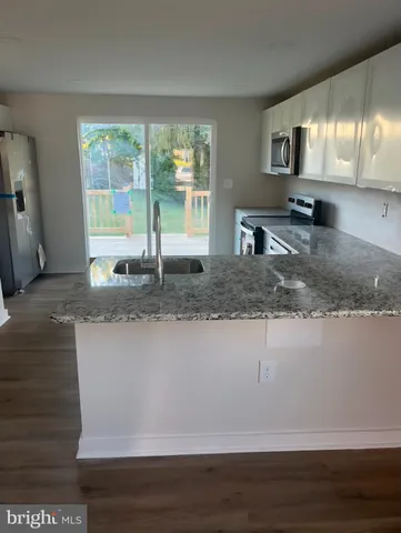 a kitchen with kitchen island granite countertop a sink window and a counter top space