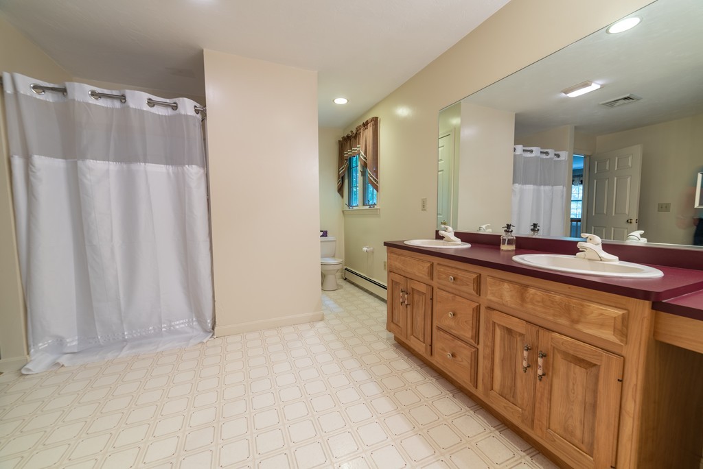 1565 West Street Wrentham, MA 02093 - Photo 28 of 30 a bathroom with a double vanity sink and mirror