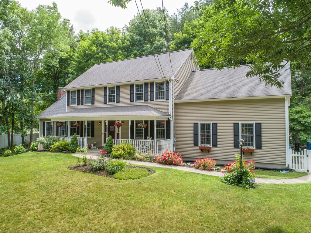 1565 West Street Wrentham, MA 02093 - Photo 3 of 30 a front view of a house with a garden and plants