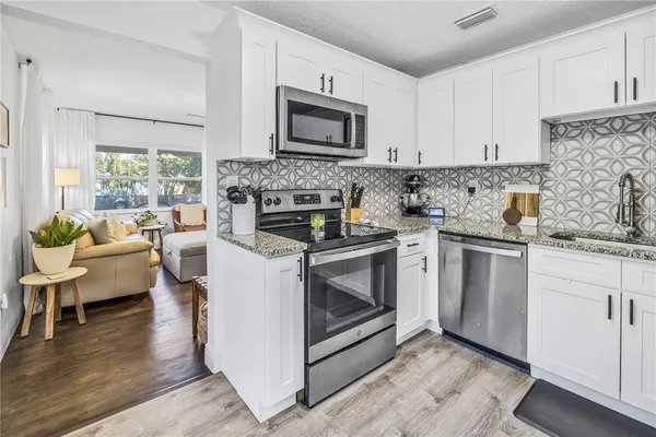 a kitchen with a stove a sink and a microwave