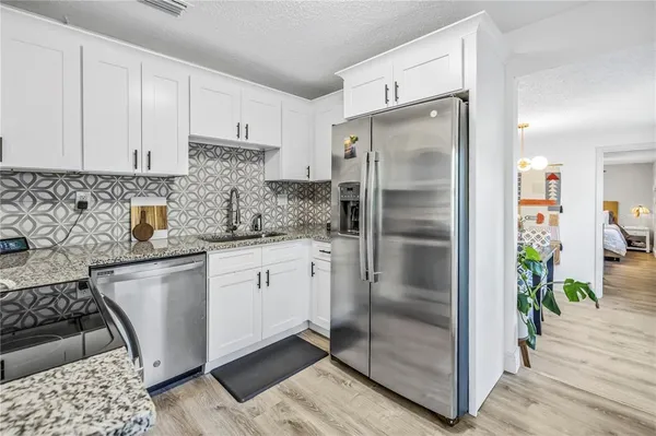 a kitchen with stainless steel appliances granite countertop a refrigerator and a sink