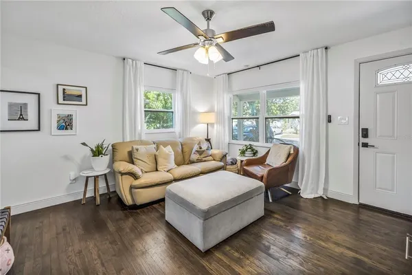 a living room with furniture and a large window with wooden floor