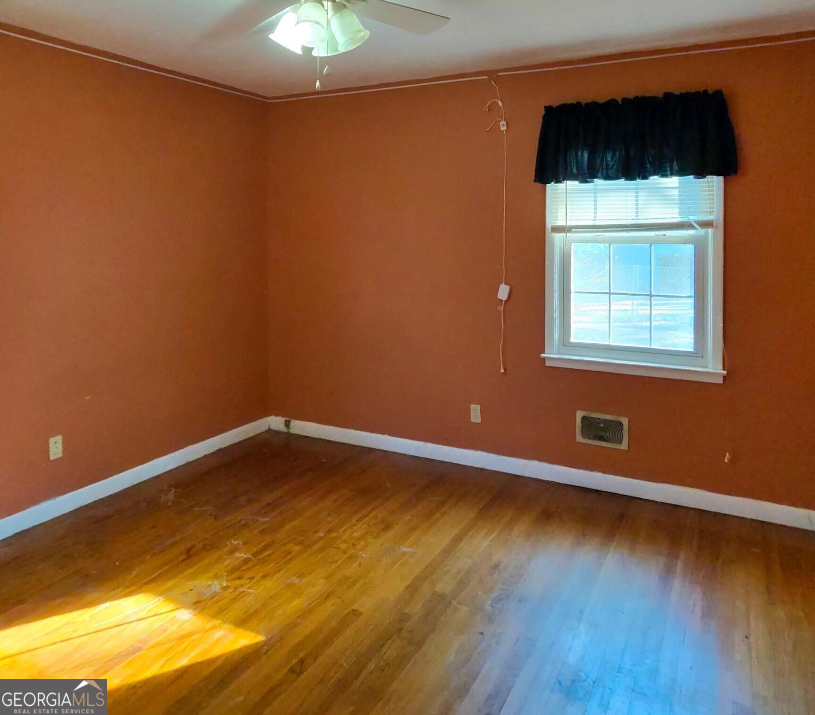 110 Lee Street Centerville, GA 31028 - Photo 7 of 16 a view of an empty room with wooden floor and a window