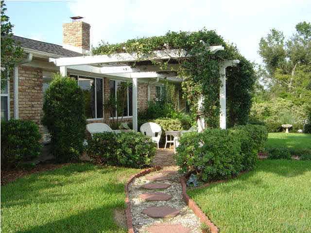 8855 Burning Tree Road Pensacola, FL 32514 - Photo 23 of 24 Bachyard looks like Southern Living. Lush lawn with lots of flowers.