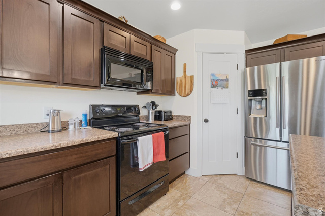 592 West 650 South Springville, UT 84663 - Photo 12 of 33 Kitchen featuring dark wood cabinetry, a stainless steel refrigerator, black range, and an over-the-range microwave