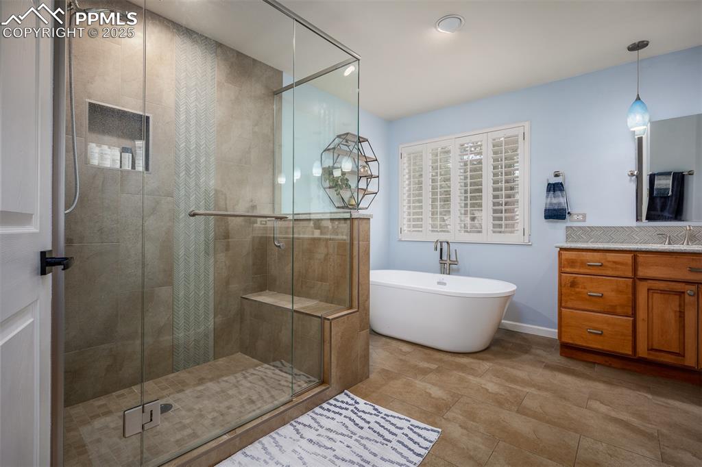 15580 Deercross Court Colorado Springs, CO 80921 - Photo 31 of 50 a bathroom with a granite countertop sink a toilet a mirror and shower