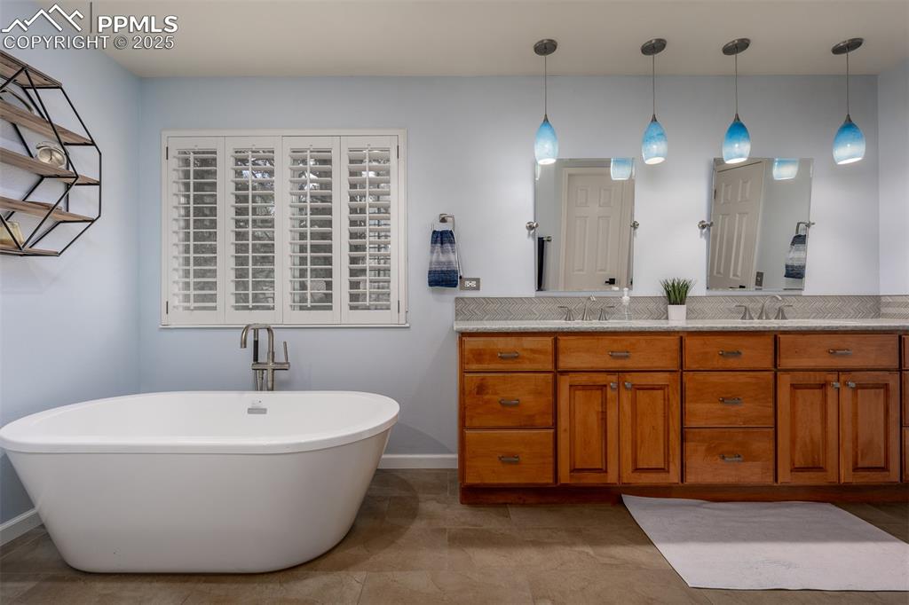 15580 Deercross Court Colorado Springs, CO 80921 - Photo 32 of 50 a bathroom with a granite countertop sink and a mirror